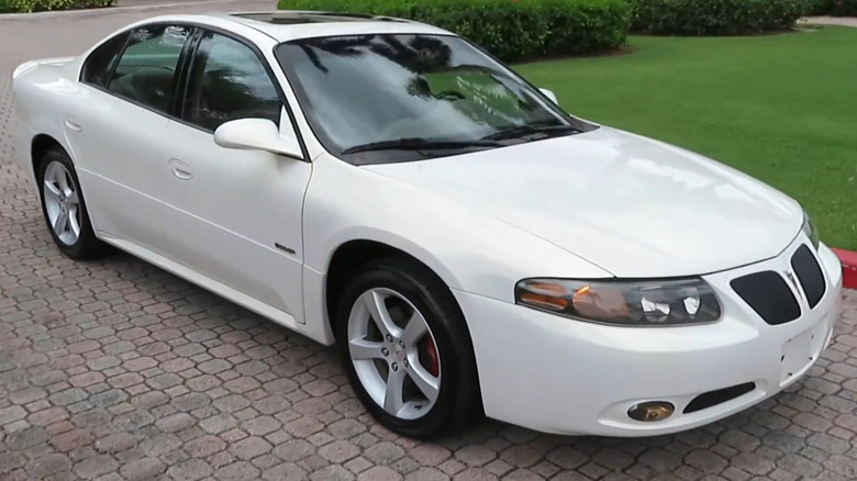 Білий седан Pontiac Bonneville GXP 2004-2005 років, припаркований на асфальтованій під'їзній доріжці.