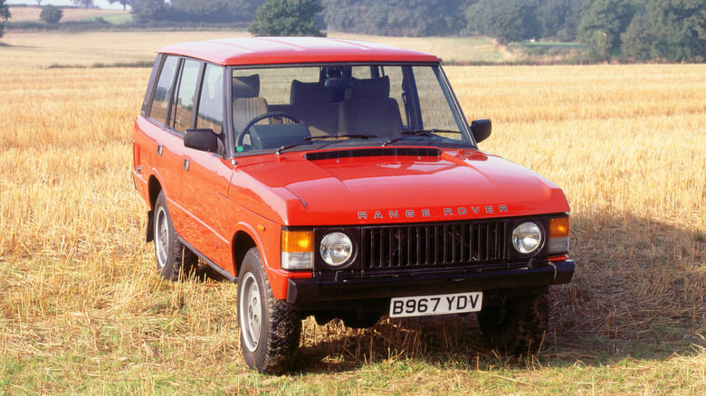 Стандартний Range Rover Classic червоного кольору, що стоїть у полі