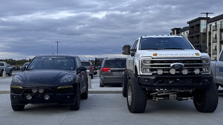 Ford Super Duty з піднятим кузовом поруч з Porsche Cayenne