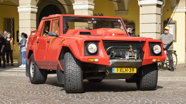 Червоний Lamborghini LM002, припаркований на вулиці.