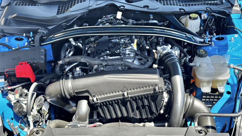 Фото під капотом синього Mustang EcoBoost, що демонструє його 2,3-літровий чотирициліндровий двигун EcoBoost.