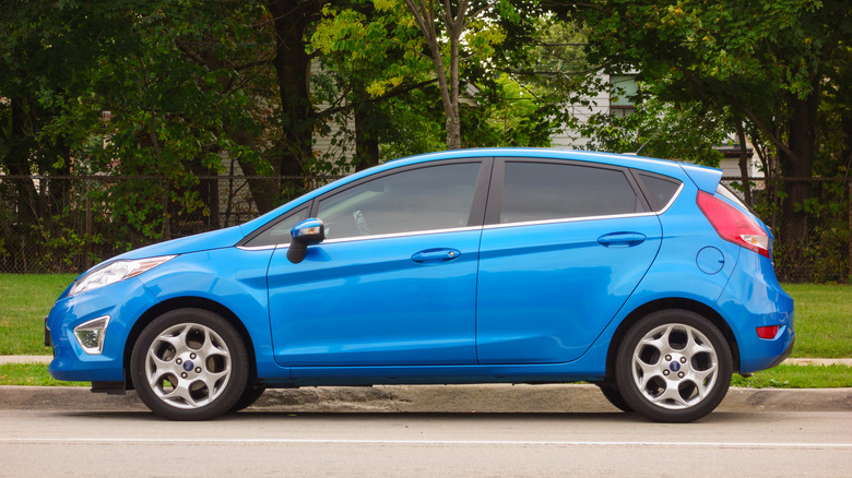 Блакитний Ford Fiesta припаркований біля тротуару