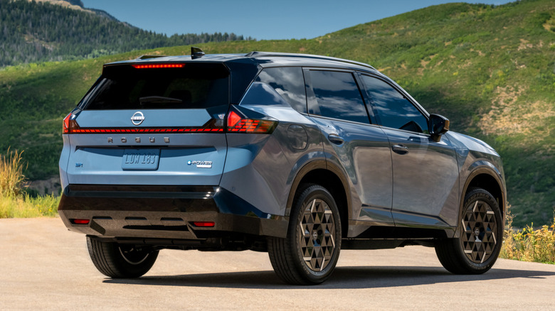 Задній 3/4 вигляд синього Nissan Rogue Hybrid 2027 року