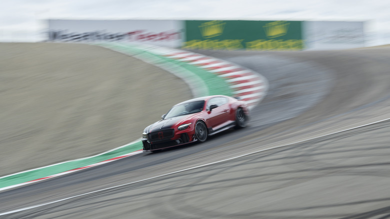 Червоний і чорний Bentley Supersports 2027 року проходить поворот Corkscrew