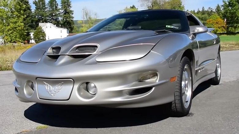 Сірий Pontiac Firebird Trans Am WS6 з функціональними повітрозабірниками Ram Air на відкритій дорозі.