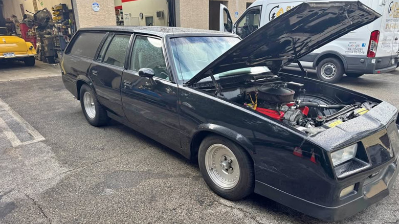 Чорний Chevy Malibu універсал з відкритим капотом