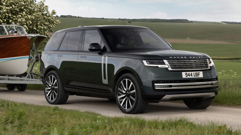 Передній тричетвертний вид зеленого Range Rover EV на буксирі