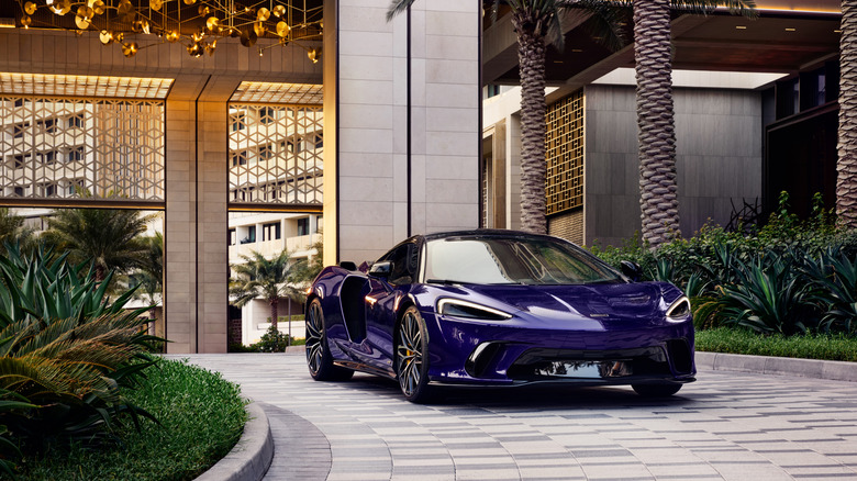 Фіолетовий McLaren GTS, припаркований перед розкішним готелем.