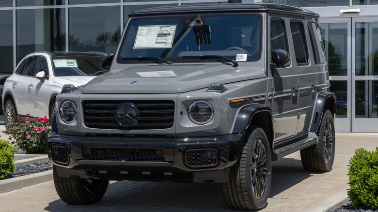 Новий сірий Mercedes-Benz G 580 з технологією EQ, припаркований перед дилером.