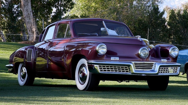 Малиновий Tucker 48, відомий як Tucker Torpedo, на зеленій галявині на автошоу.