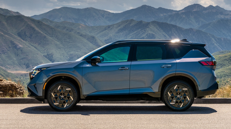Бічний вигляд синього Nissan Rogue Hybrid 2027 року