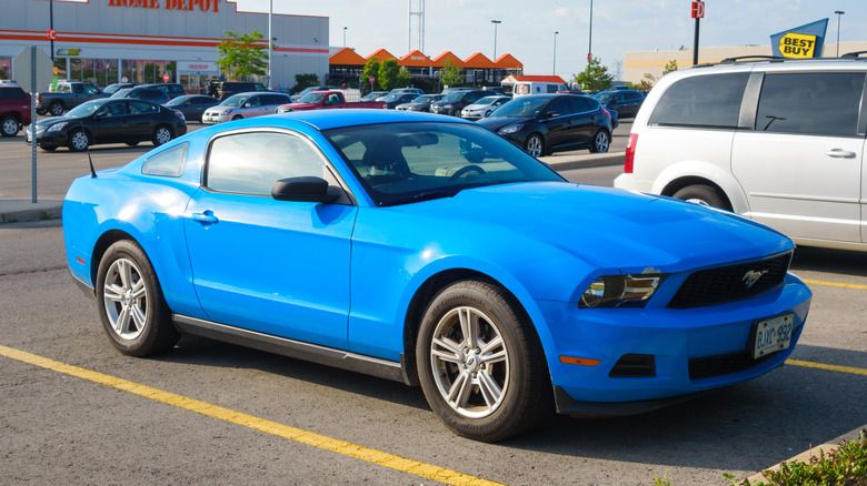 Синій Ford Mustang 2007 року, припаркований на стоянці біля Home Depot і Best Buy.