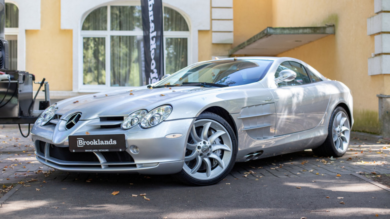 Сріблястий Mercedes McLaren SLR, припаркований на міській вулиці.