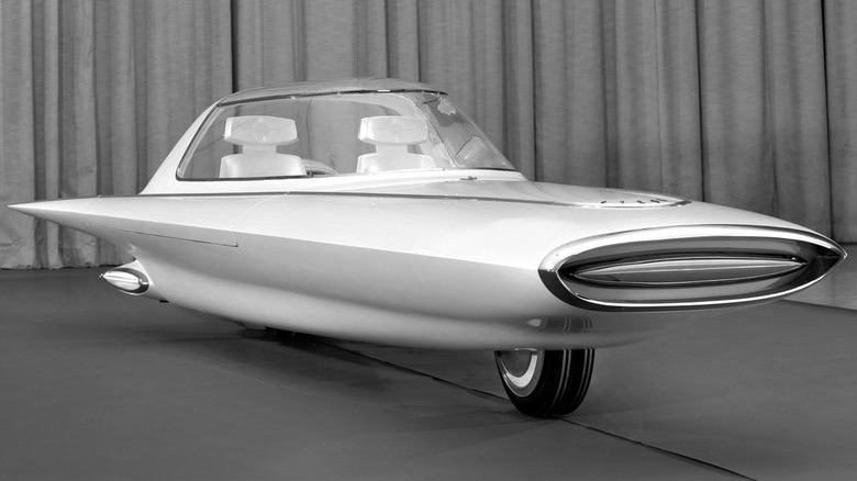 Чорно-біле фото концепт-кара 1961 Ford Gyron, що показує його двоколісний гіроскопічно збалансований корпус-шпиндель, широкий горизонтальний обтічник передньої решітки та кабіну-бульбашу в стилі реактивної епохи.