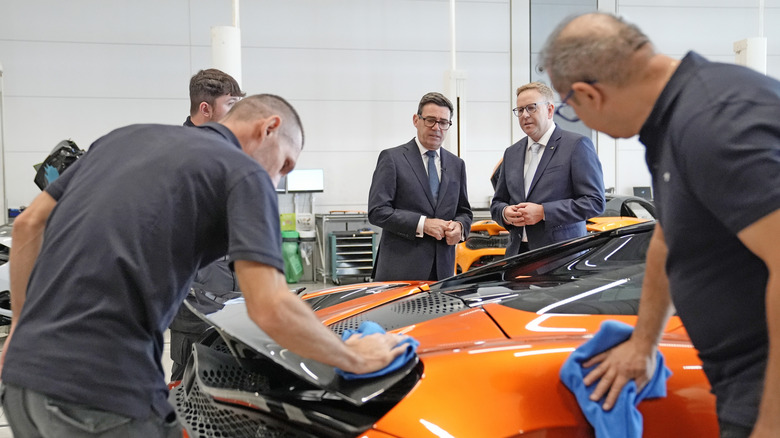 WOKING, ENGLAND - SEPTEMBER 16: Nick Collins, Chief Executive Officer of McLaren Group with Prime Minister Andy Burnham (centre) during a visit to meet apprentices and workers on the production lines at the McLaren Technology Centre on September 16, 2026 in Woking, England. (Photo by Stefan Rousseau - WPA Pool/Getty Images)