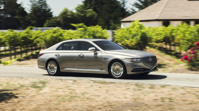 Сріблястий Genesis G70 2021 року в русі на дорозі.