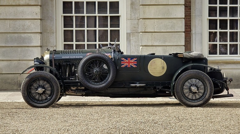 Зелений Bentley Blower з відкритим верхом на тлі старої англійської садиби.