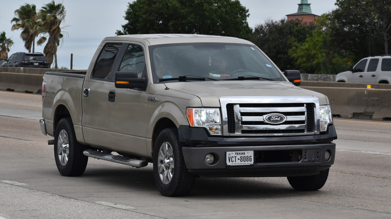 Золотистий Ford F-150 2013 року їде по шосе.