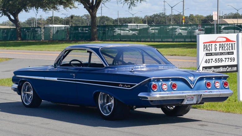 Модифікований Chevrolet Impala Bubbletop 1961 року демонструє свій задній дизайн поруч зі знаком