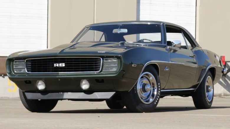 Темно-зелений Chevrolet Camaro RS COPO ZL1 1969 року з капотом з повітрозабірником та прихованими фарами.
