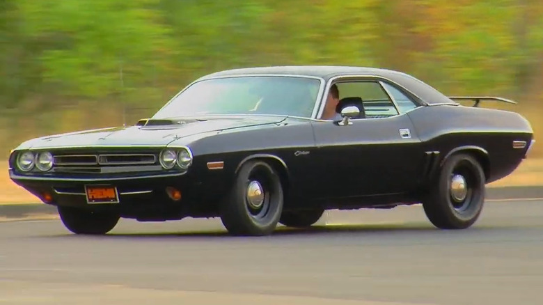 Чорний Dodge Challenger R/T 1970 року, що їде по трасі з капотом-шноркелем.